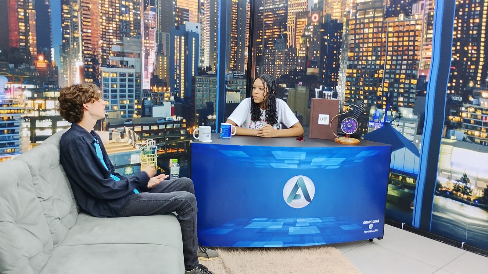 Jovens do Projeto Portal do Tijuco Preto experimentam entrevistas em bancada no estúdio da TV Attual.